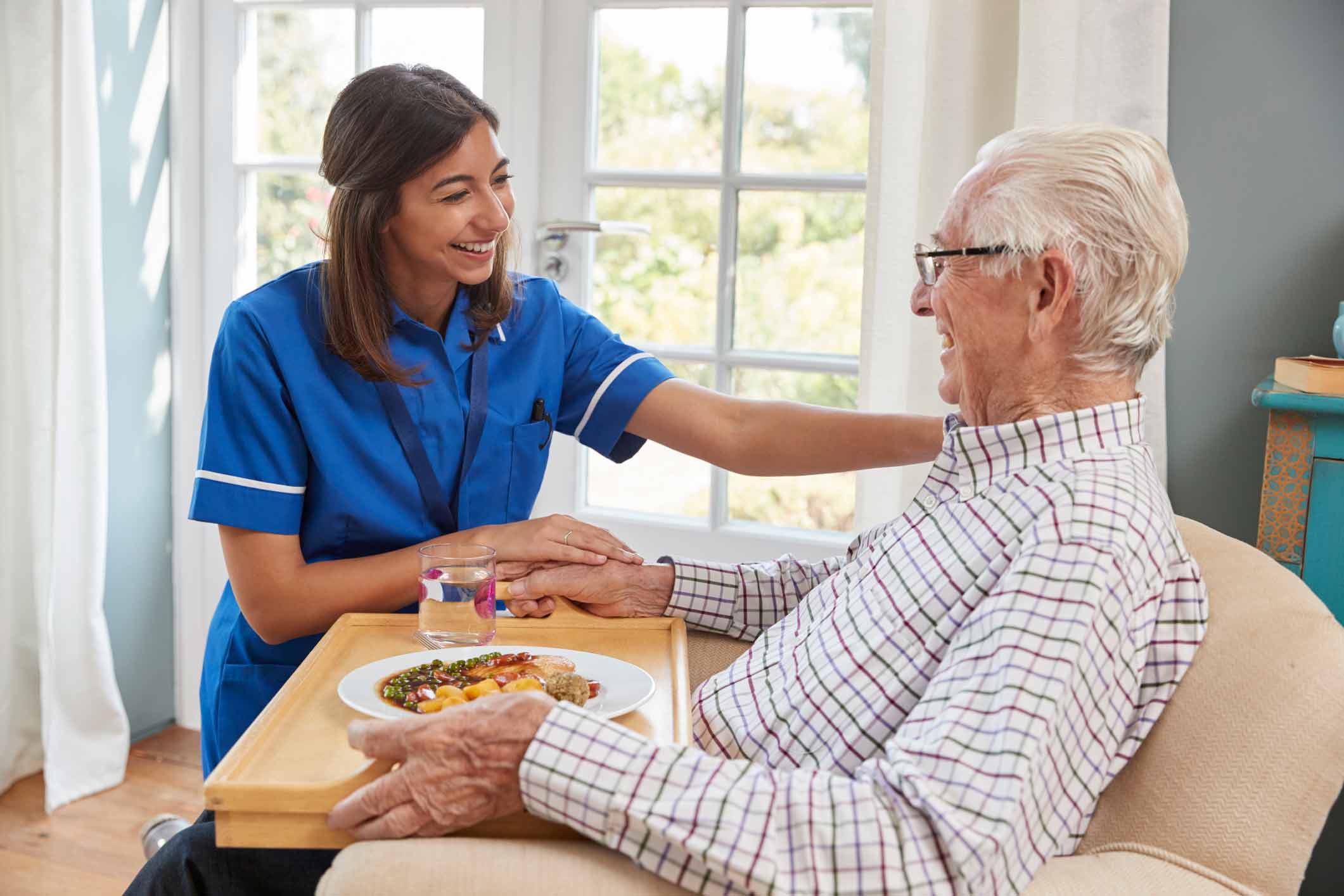 Elderly care home patient being fed by nurse