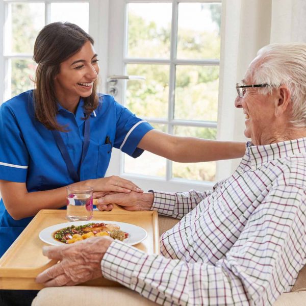 Elderly care home patient being fed by nurse